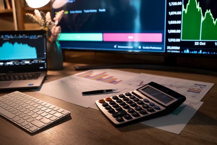 a desk with a laptop and a calculator