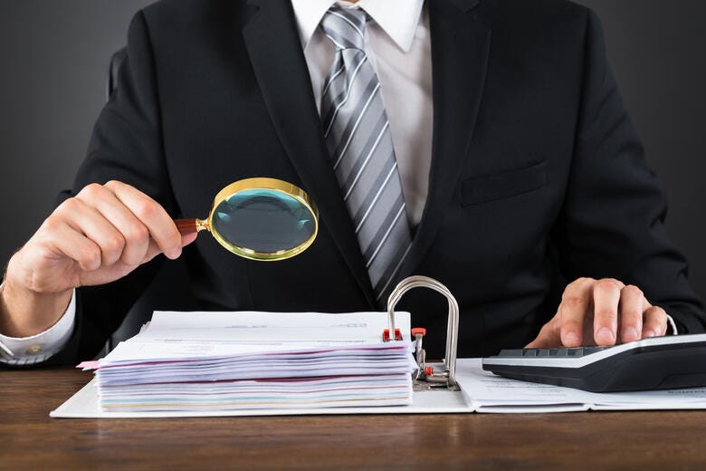 a man in a suit and tie writing on a book