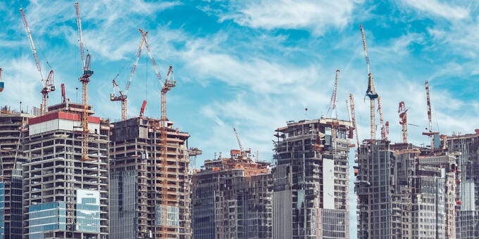 a group of buildings with cranes