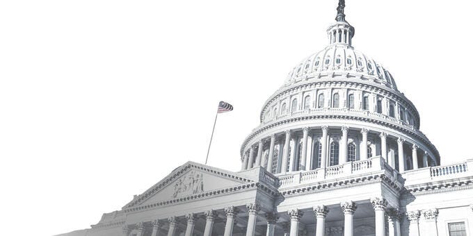 a large white building with columns and a flag on top with United States Capitol in the background