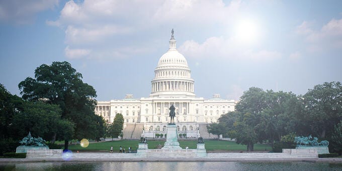 a white building with a dome and a fountain in front of it