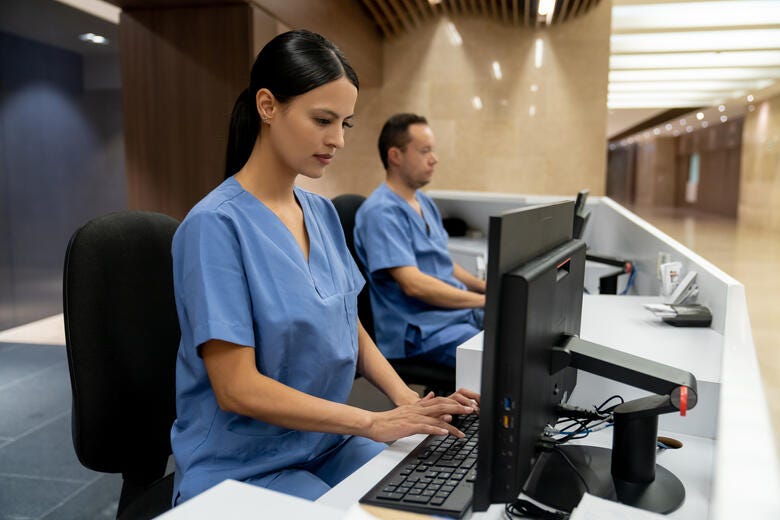 a man and a woman working on a computer