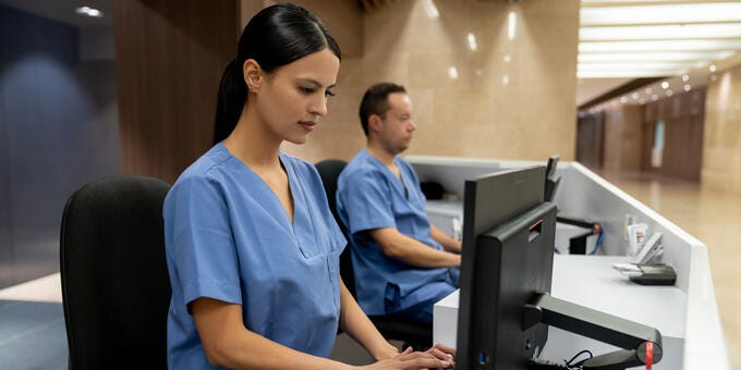 a man and a woman working on a computer