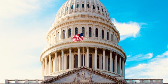 a large white building with a flag on top with El Capitolio in the background