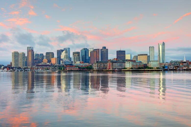 a city skyline with a body of water in front of it