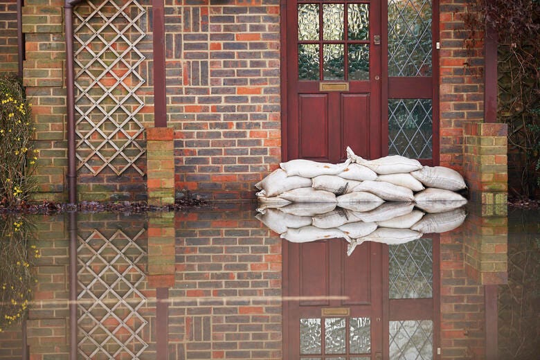 a brick building with a door and a blanket from the window