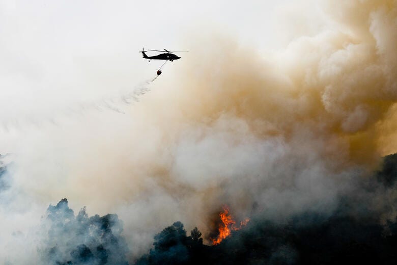 a helicopter flying over a forest