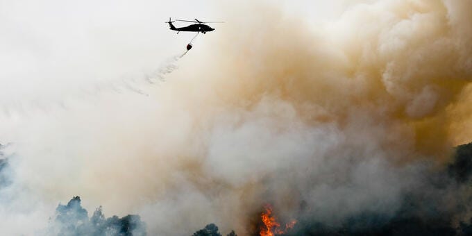 a helicopter flying over a forest