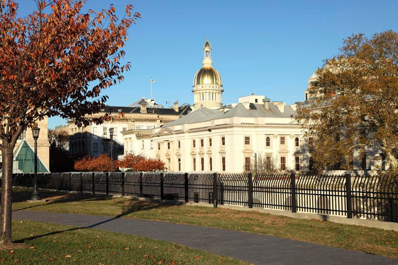 a large white building with a domed roof and a fence in front