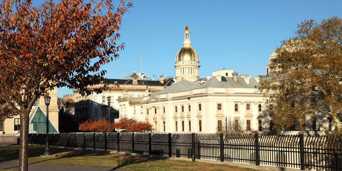 a large white building with a domed roof and a fence in front