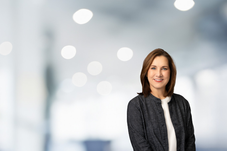 a woman smiling in front of a white background